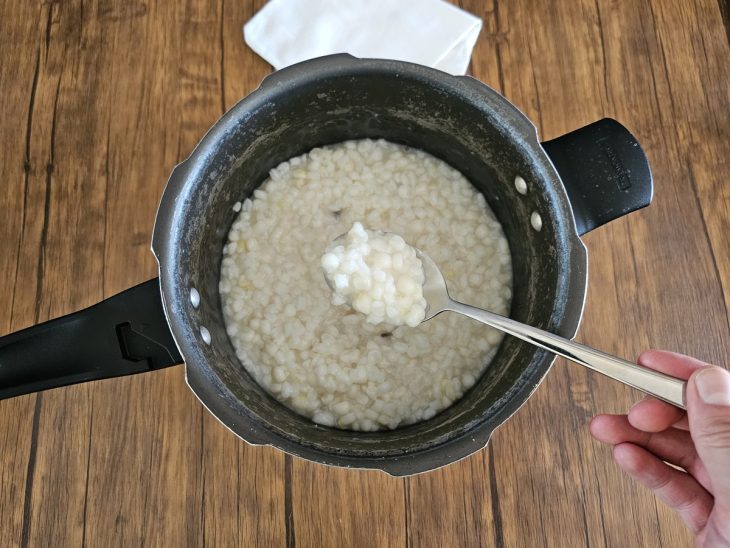 Uma panela de pressão com canjica cozido.