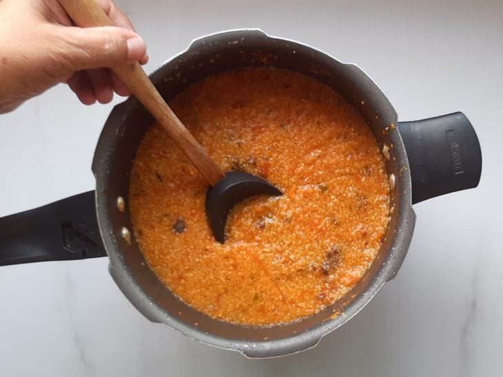 Uma panela de pressão contendo canjiquinha salgada.