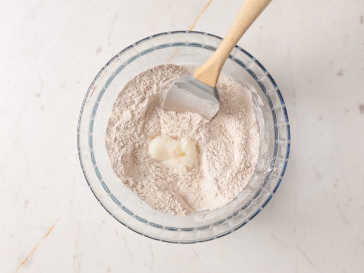 Uma tigela com a mistura dos ingredientes secos e banha.