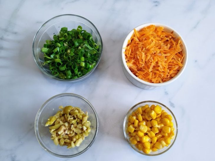 Recipientes com ingredientes picados e ralados.