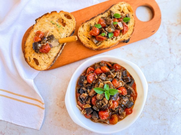Caponata pronta, servida com pão ou como acompanhamento.