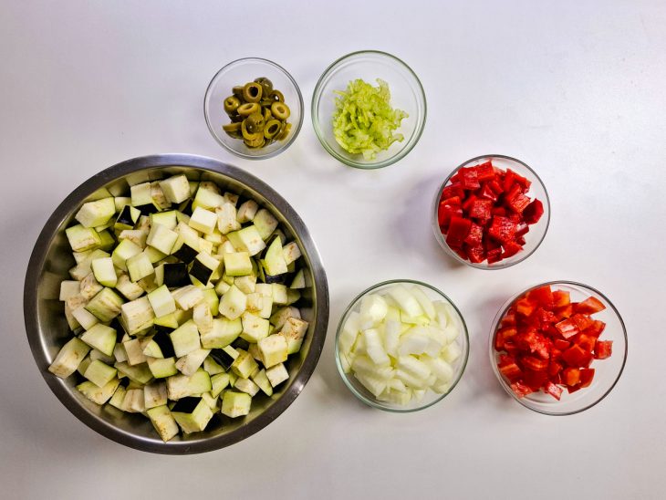 Berinjelas e legumes cortados em cubos.