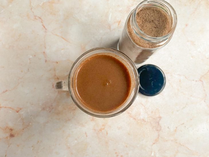 Uma xícara com capuccino e leite.