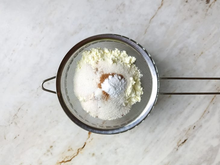 Na peneira, o café solúvel, leite em pó, o chocolate em pó, o açúcar, a canela e o bicarbonato.