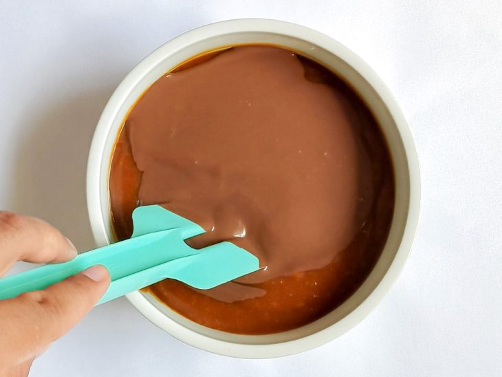 Chocolate derretido e creme de leite adicionados no caramelo.