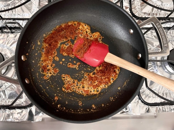 Uma frigideira com a mistura e extrato de tomate.