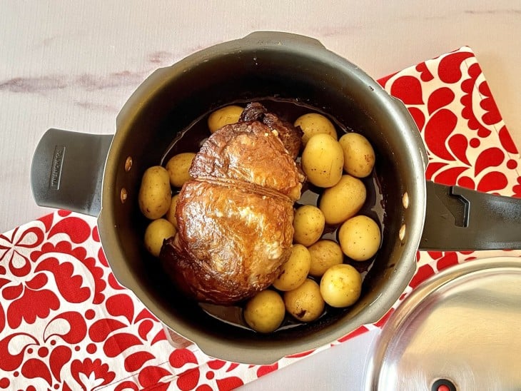 Panela de pressão com carne e batatas bolinhas.