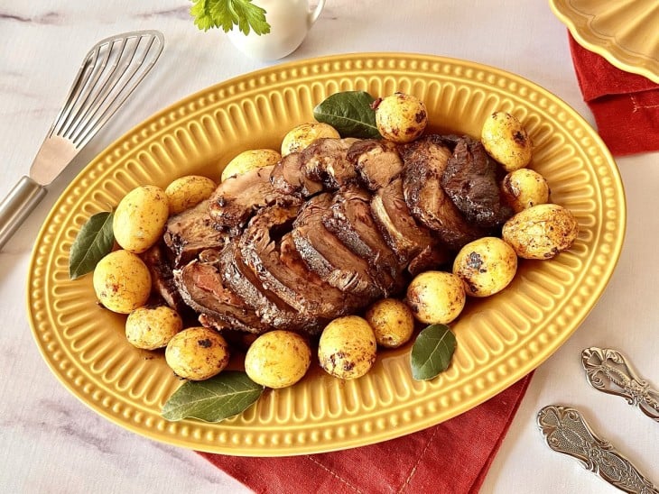 Carne fatiada em prato de cor amarela.