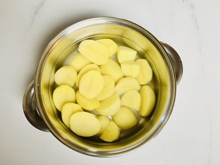 Batatas dentro de uma panela com água.