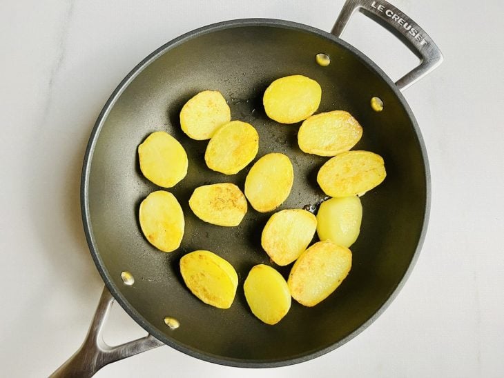 Batatas dourando dentro da frigideira.