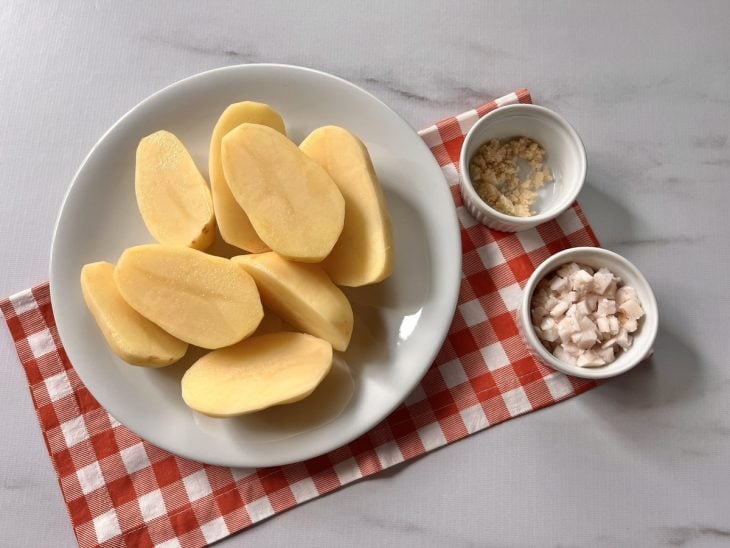 Batatas e temperos cortados e distribuídos em recipientes diferentes.