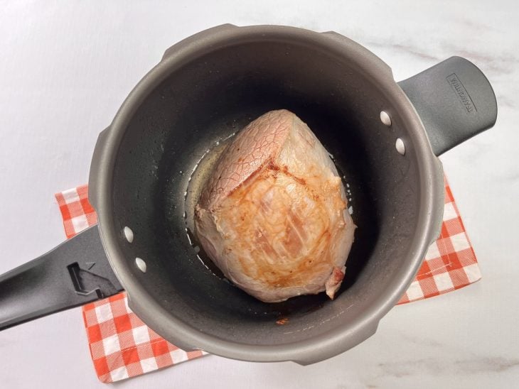 Panela de pressão com peça de carne inteira.