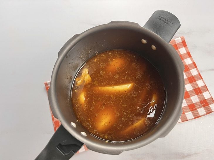 Panela de pressão com molho e batatas.