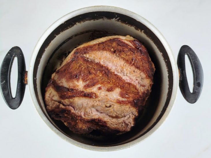 Carne selada em uma panela de fundo grosso.