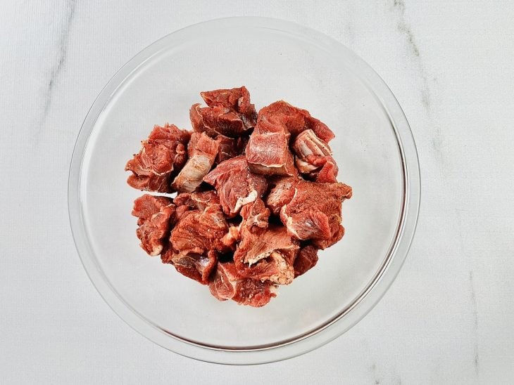 Carne temperada em uma tigela de vidro.