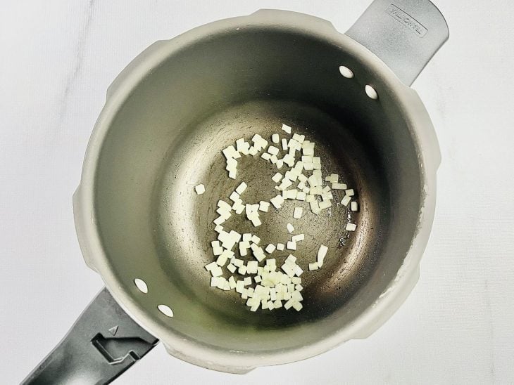 Cebola refogada com azeite na panela de pressão.