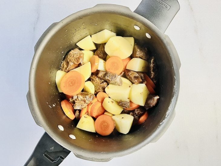 Cenoura e batatas adicionadas na panela.