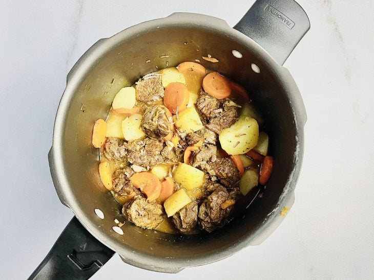 Carne com batata e cenoura cozidas na panela.