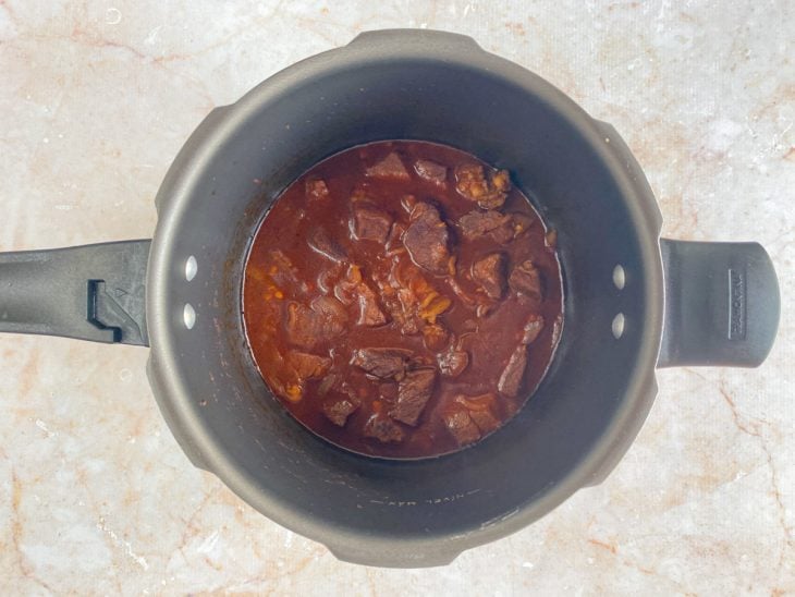 Carne e molho formado na panela de pressão.