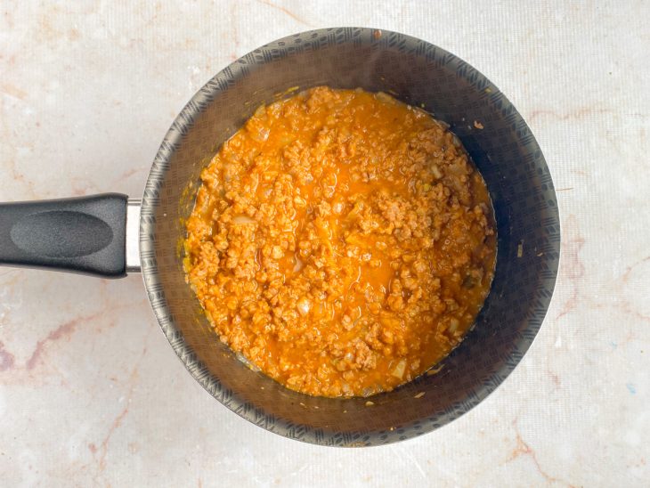 Proteína de soja com ketchup, água e molho de tomate em uma panela.