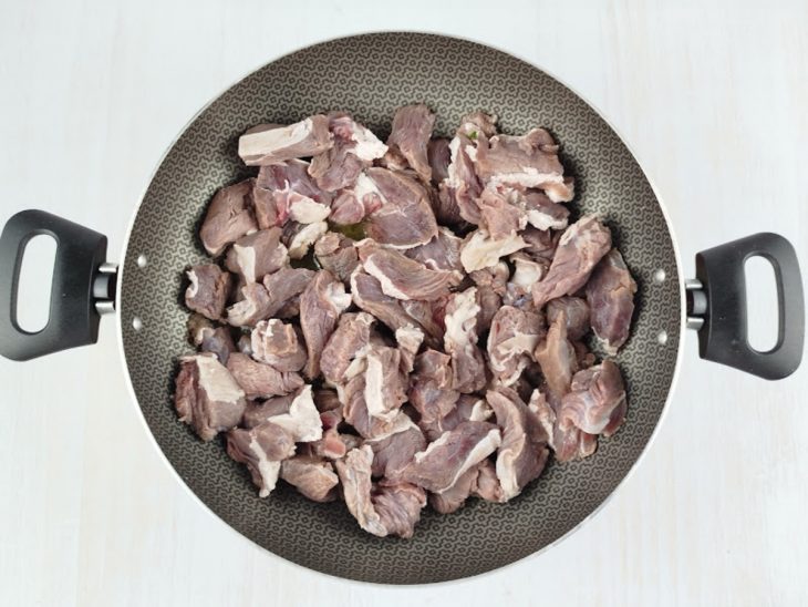 Carne refogando numa panela com manteiga de garrafa.