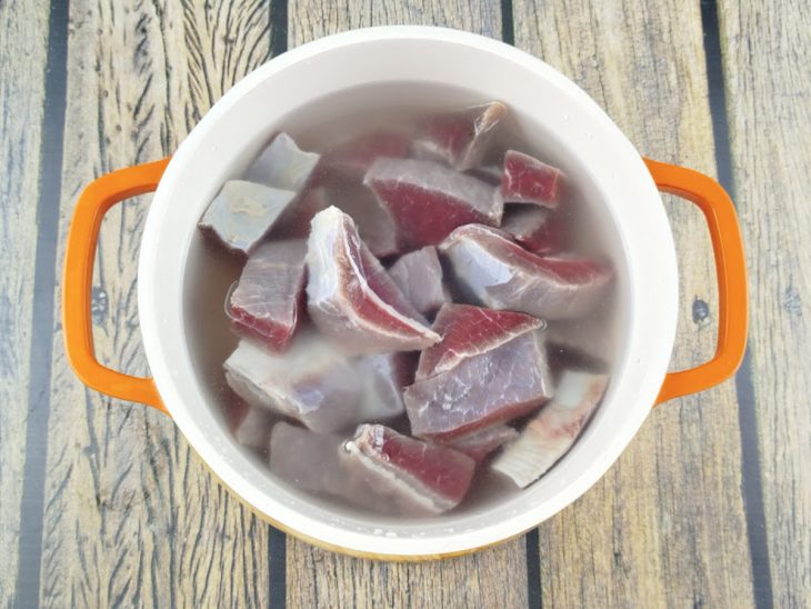 Carne de sol fervendo em água com limão para dessalgar.