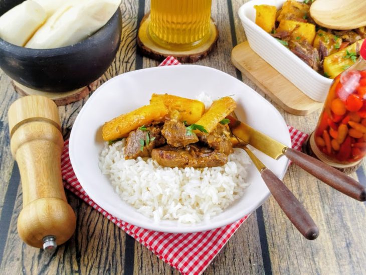 Carne de sol com mandioca servida no prato com arroz.