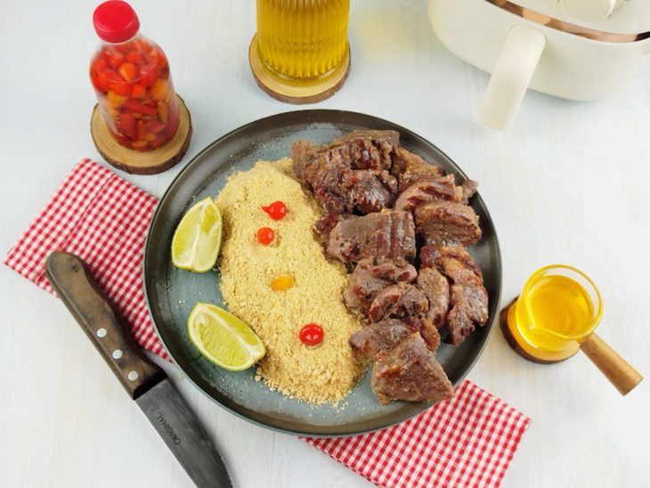 Carne de sol pronta, dourada e suculenta, servida com farofa.
