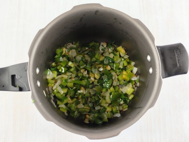 Pimentão e cheiro-verde adicionados na panela.