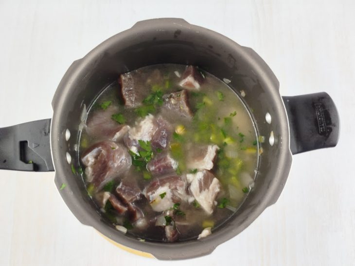 Ingredientes na panela, cobertos com água.