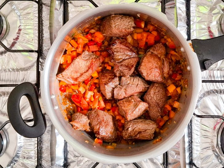 Carne e outros ingredientes adicionados na panela com o refogado.
