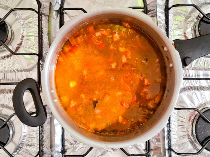 Caldo de carne colocado na panela.