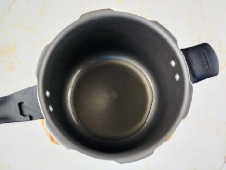 Azeite aquecendo em uma panela de pressão.