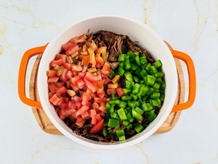 Tomate e pimentão adicionados a panela com carne desfiada.