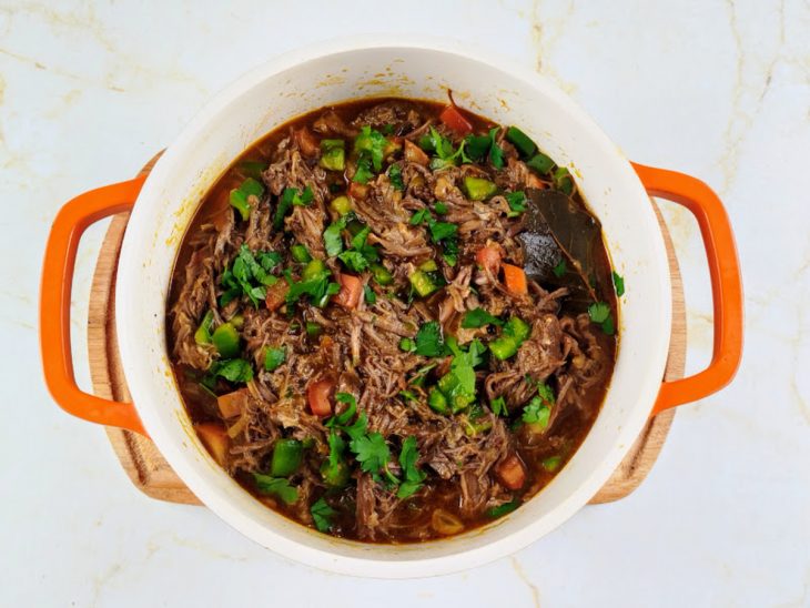 Cheiro-verde e caldo da carne adicionado a panela.