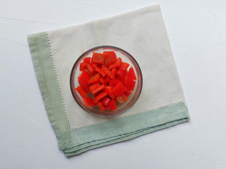 Um recipiente contendo pimenta vermelho picado.