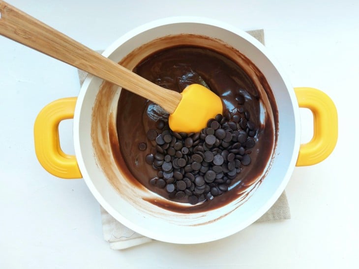 Chocolate preto em gotas sendo adicionado ao brigadeiro.
