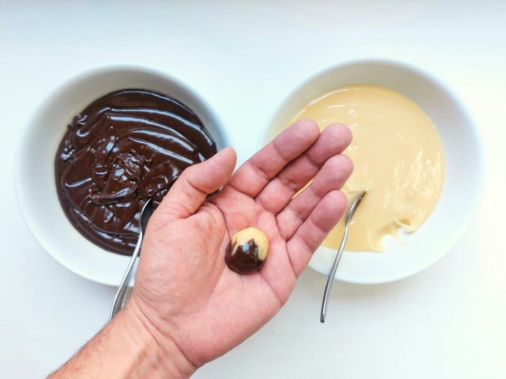 Brigadeiro e brigadeiro branco enrolados em apenas uma bolinha.