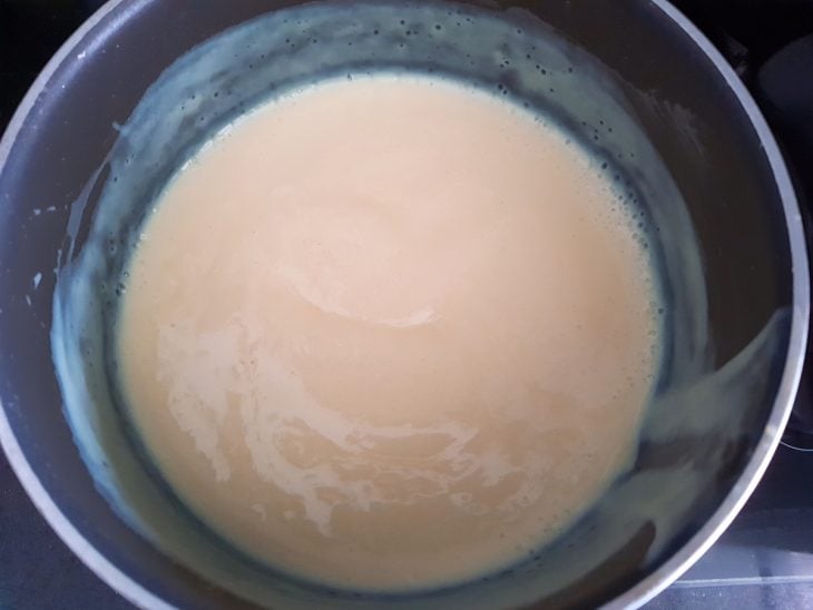 Uma panela com gemas, leite condensado e leite.