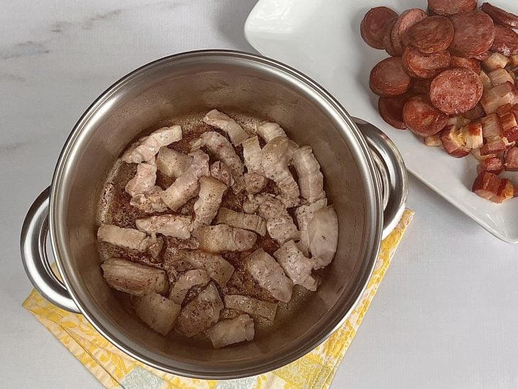 Uma panela com barriga de porco a dourar.