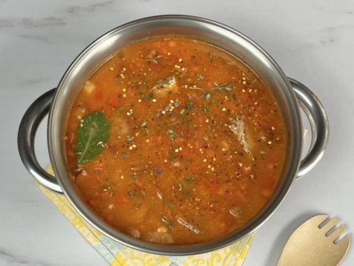 Uma panela com a mistura do molho, carnes e feijão.