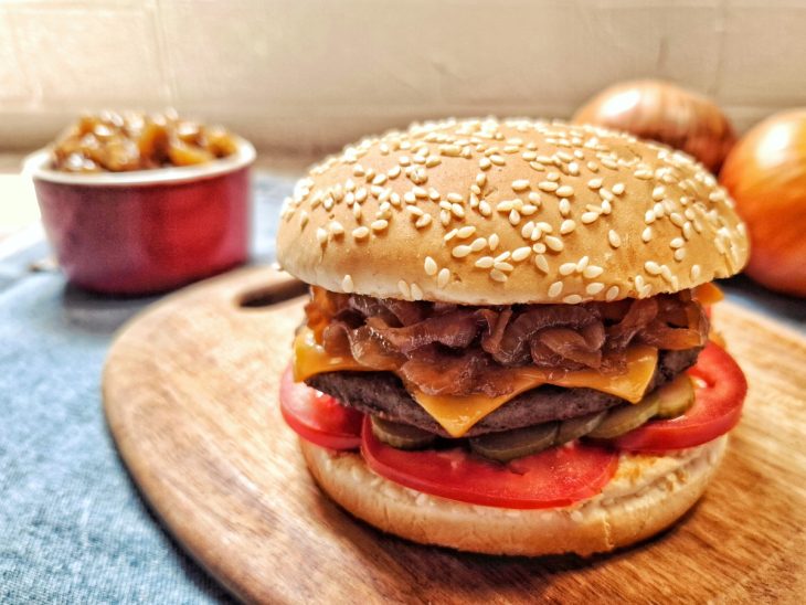 Cebola caramelizada fácil e rápida em um hambúrguer.