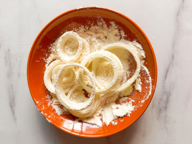 Anéis de cebola empanados na farinha.