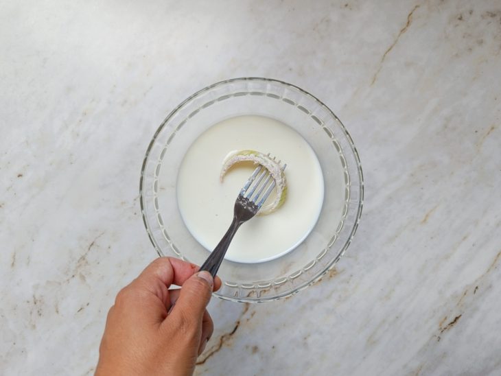 Anel de cebola empanado e mergulhado no leite.