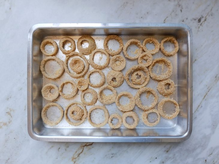 Anéis de cebola numa assadeira.