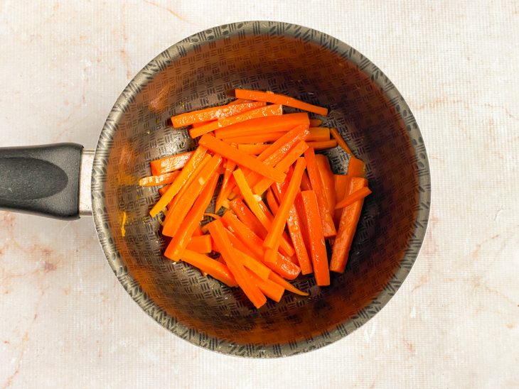 Na panela com a manteiga, as cenouras são adicionadas.