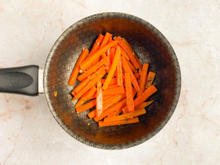 Na panela com as cenouras, orégano é adicionado.