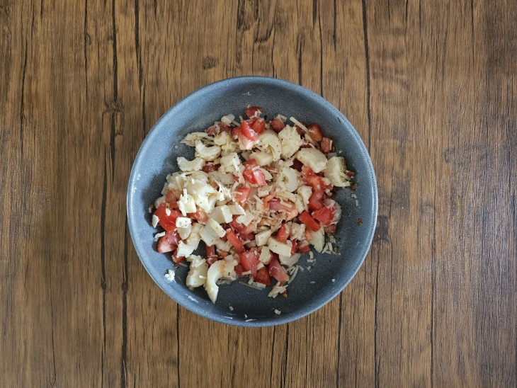 Recheio de tomate, palmito e queijo ralado misturado em um recipiente.