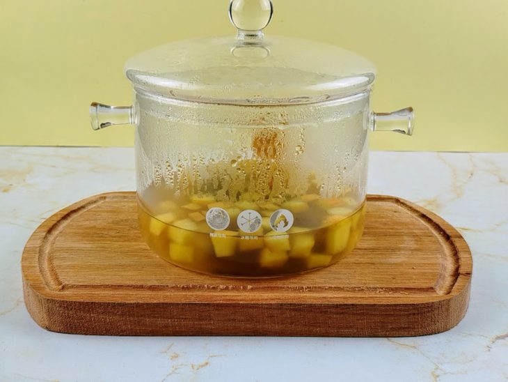 Sachês de chá, maçãs picadas e água em uma panela.