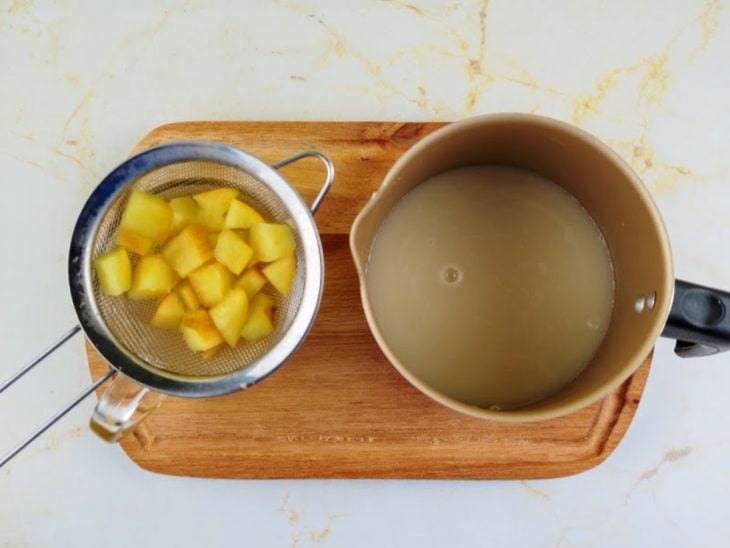Infusão coada em uma xícara e leite de aveia com mel em uma caneca de alumínio ao lado.